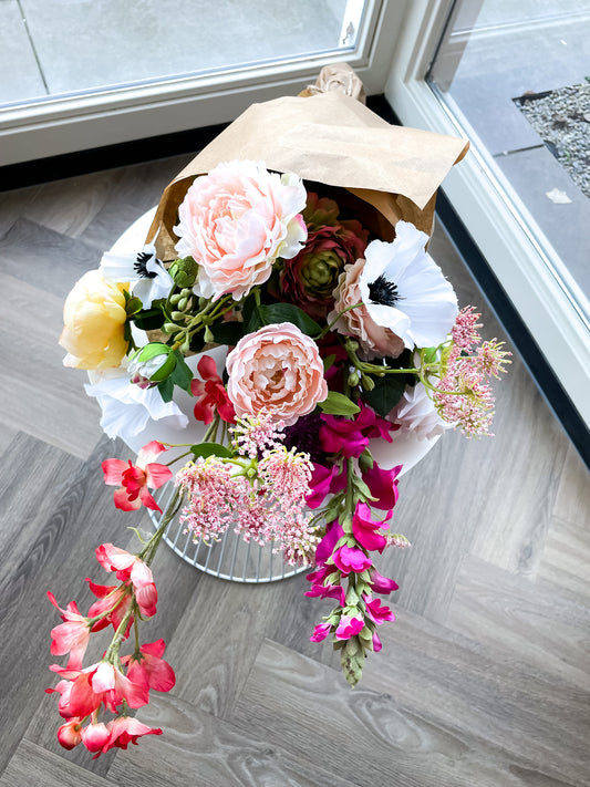 Zijden bloemen boeket in vrolijke kleuren met pioenrozen, delphinium, ranonkel en dille tak.