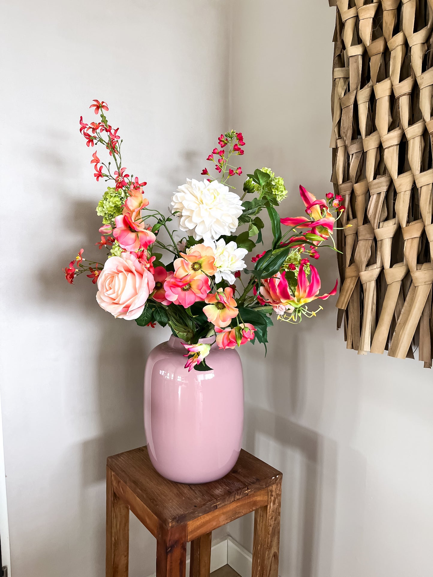 Poeder roze glazen vaas met kleurrijk zijden bloemenboeket bestaande uit rozen, dahlia's en tropische bloemen. Passend bij elk interieur.