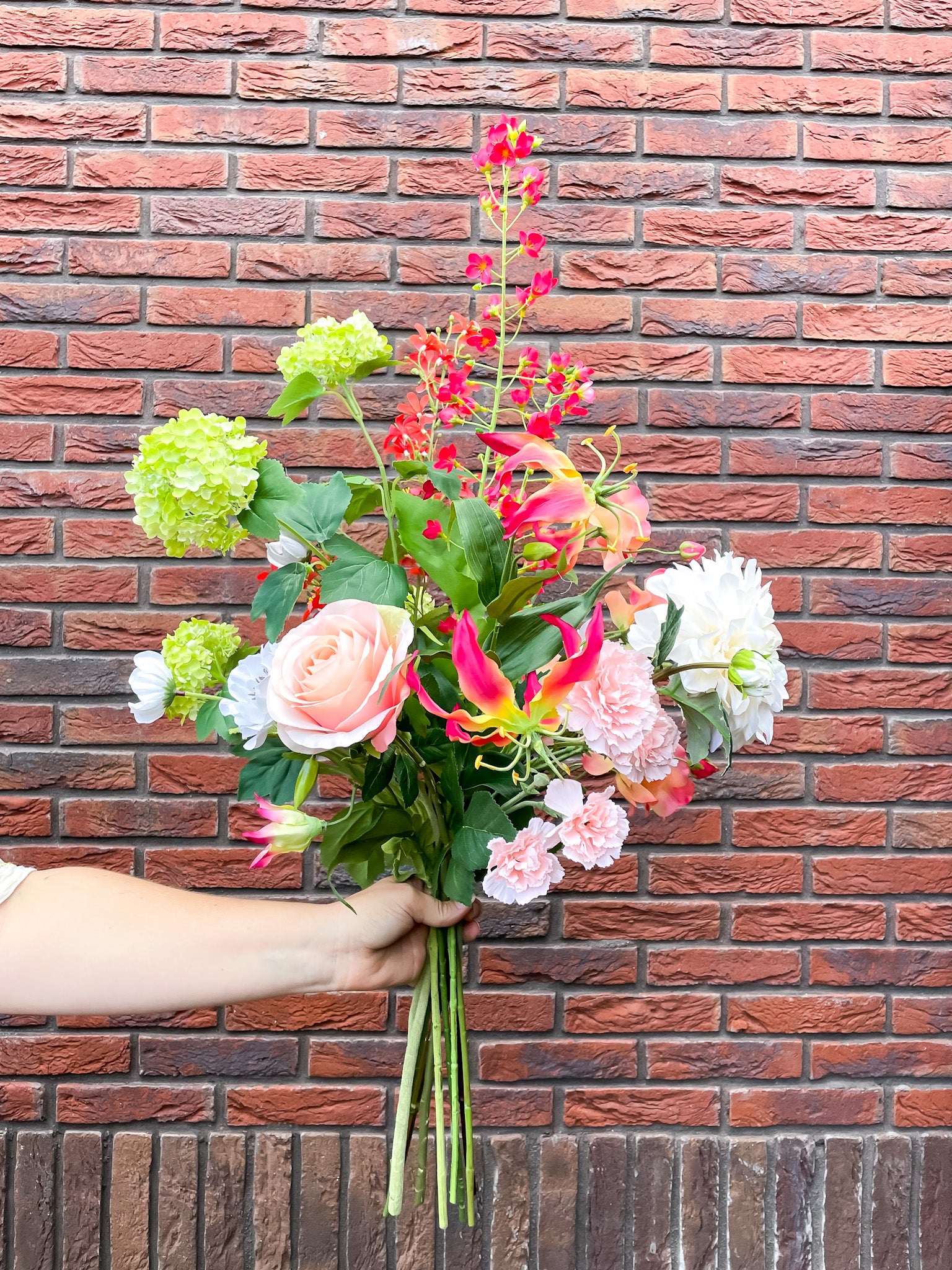 Kunstbloemen in frisse zomerse kleuren, zoals roze, fuchsia, groen en wit.