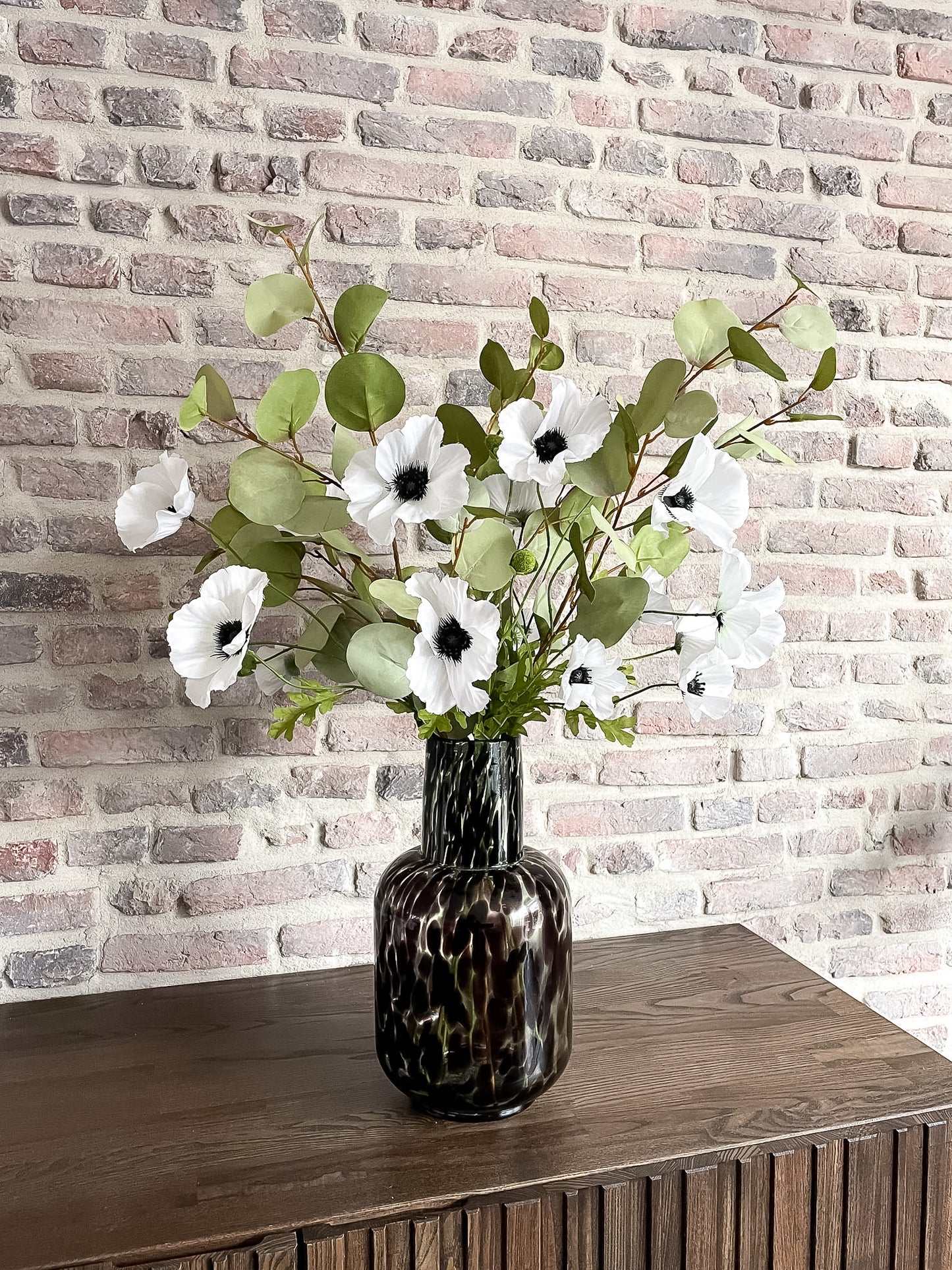 Natuurlijk zijden boeket met witte bloemen en groen blad.