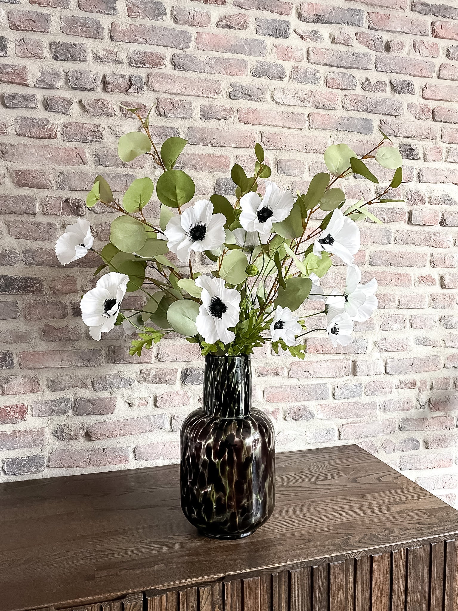 Natuurlijk zijden boeket met witte bloemen en groen blad.