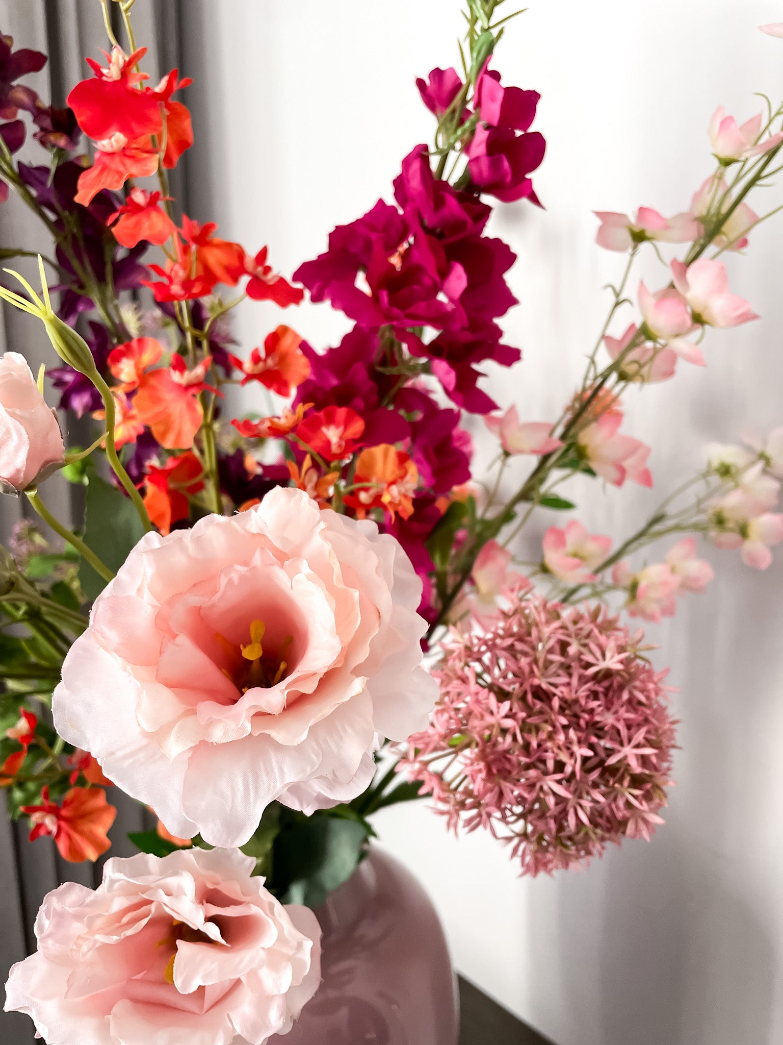 Details van zijden bloemen in het oranje, roze en magenta. 