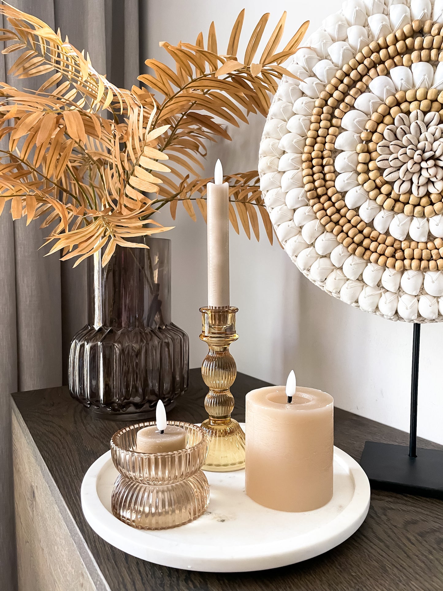 Goudkleurige set woonaccessoires met marmer dienblad en schelpenornament.