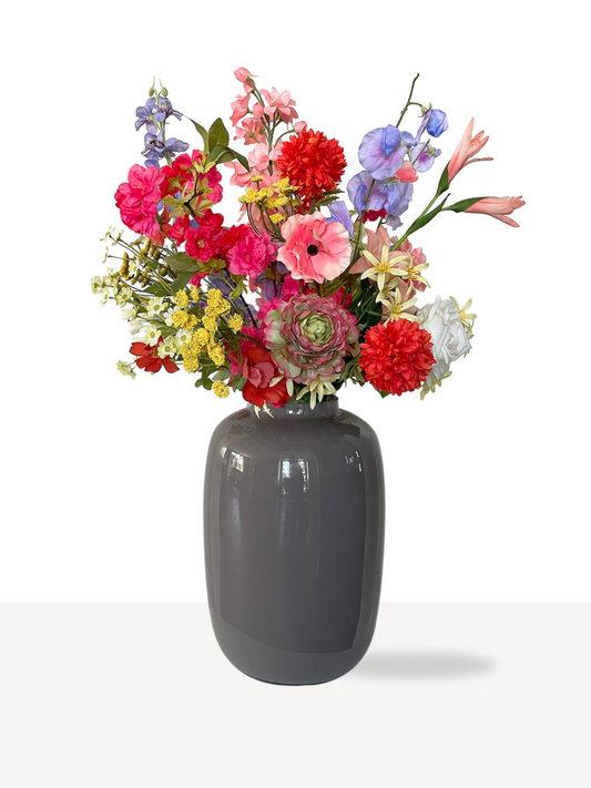 Zijden bloemen boeket in felle zomerse kleuren zoals, rood, roze, geel, lila, fuchsia, oranje en wit. Een groot en vol boeket met kunstbloemen.