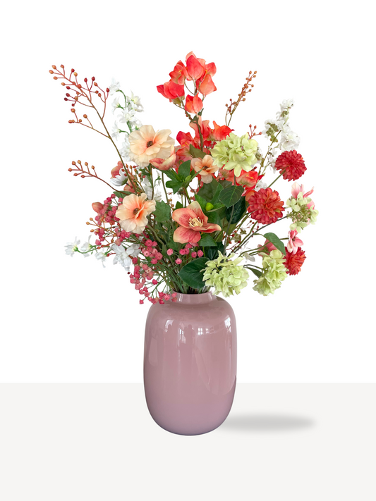 Kleurrijk zijden boeket met kunstbloemen in roze vaas, tinten roze, oranje en groen.