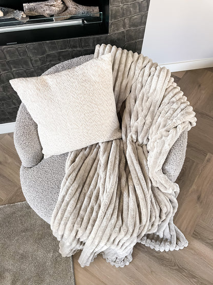 Zacht beige fleece plaid met ribstructuur, perfect voor decoratie over de bank of lekker warm om onder te zitten. Krijg een warme en knusse sfeer in huis met deze deken.