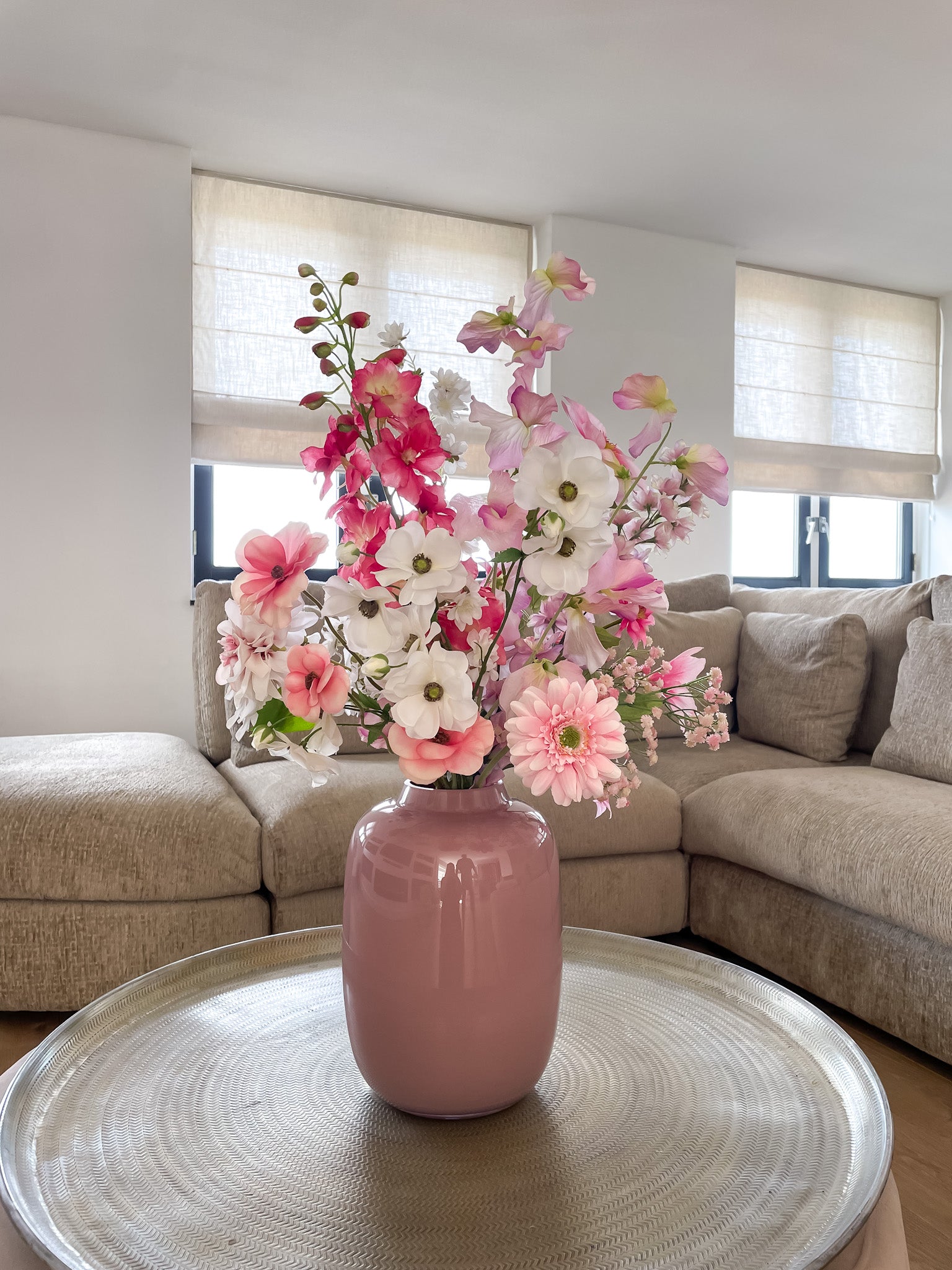 Zijden boeket in fuchsia, lichtroze en wit in pastel roze vaas met gerbera, ranonkels, delphinium, lathyrus, bloesem, gips en dahlia