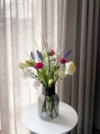 Paasboeket met witte tulpen, ranonkels, bloesem en blauwe druifjes.