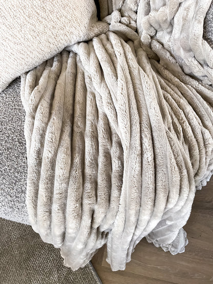 Een plaid van zachte en warme stof in een ribpatroon. De rustige kleur zorgt ervoor dat het plaid perfect is voor ieder interieur. 