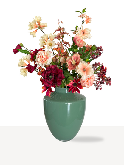 Zijden boeket met kunstbloemen in warme sfeervolle kleuren en perzik tinten. Een boeket met gips, een bloesemtak, ranonkels en rozen.