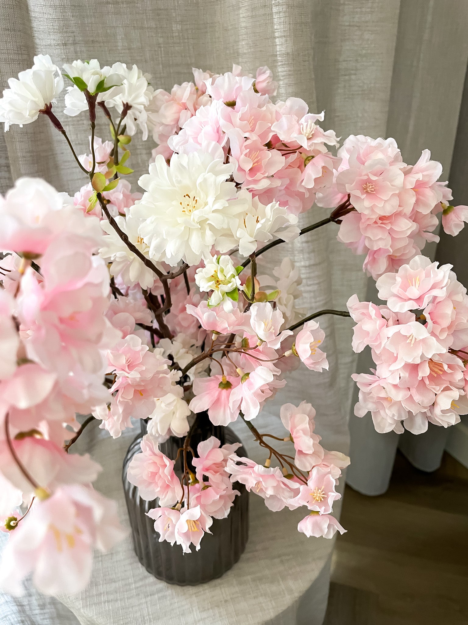 Bloesem boeket in het roze en wit in ribbel vaas