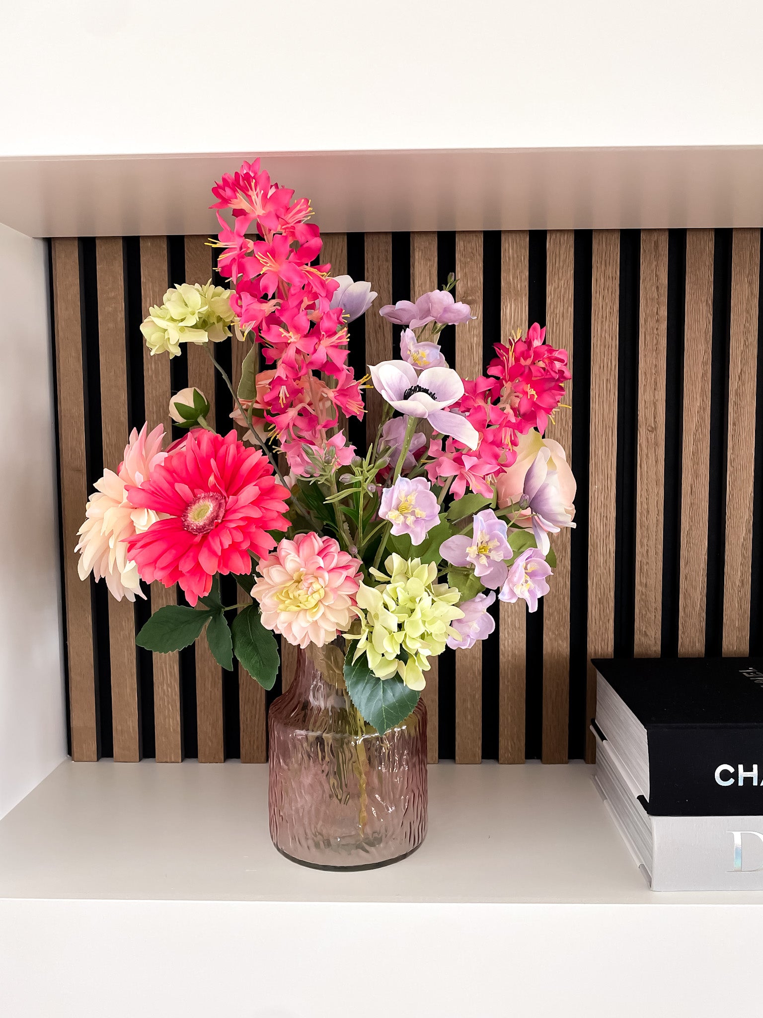 boeket met felle kleuren in roze glazen vaasje