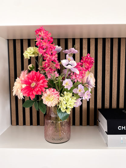 boeket met felle kleuren in roze glazen vaasje