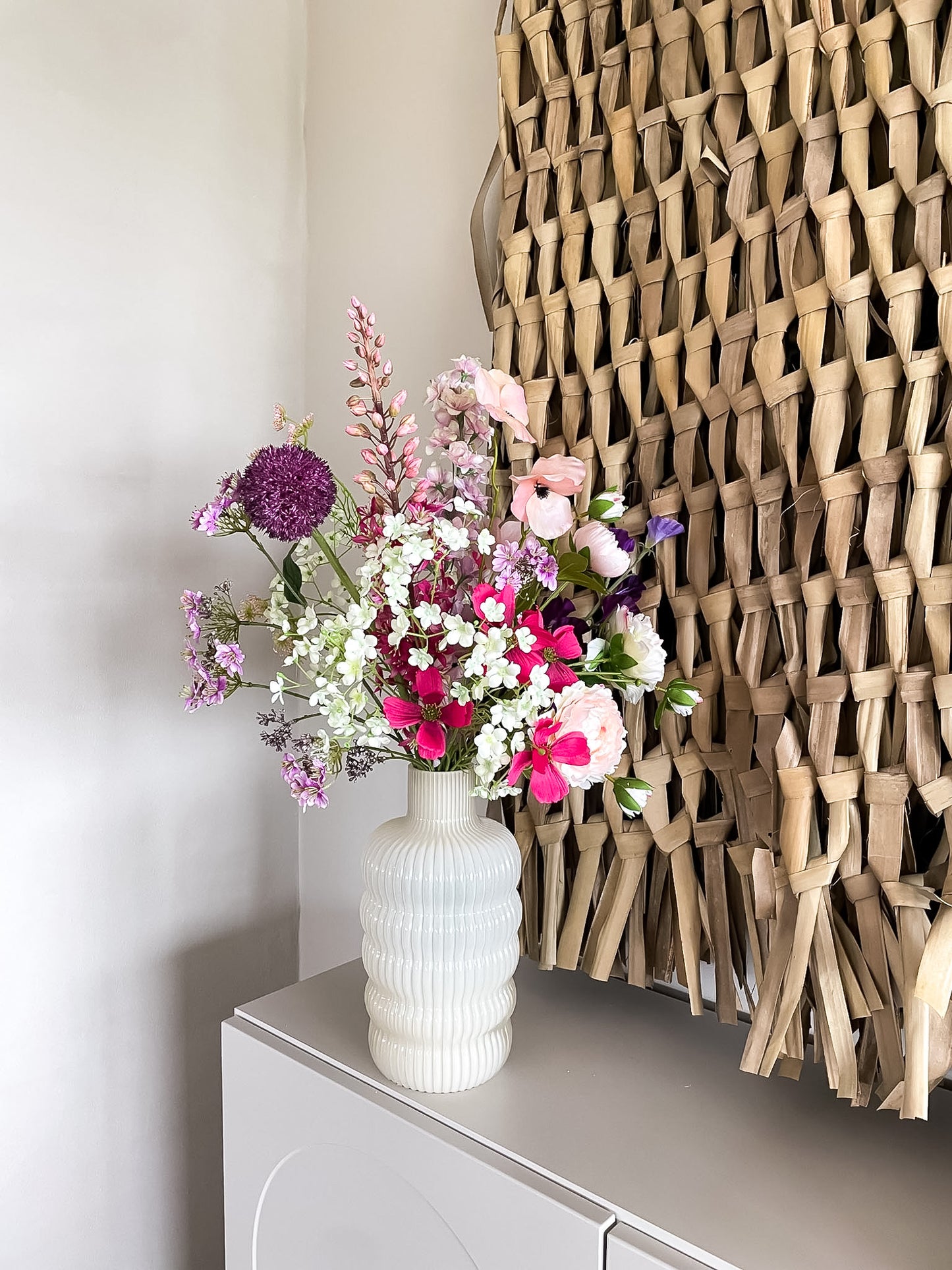 boeket met de kleuren wit, roze en paars in ribbel vaas