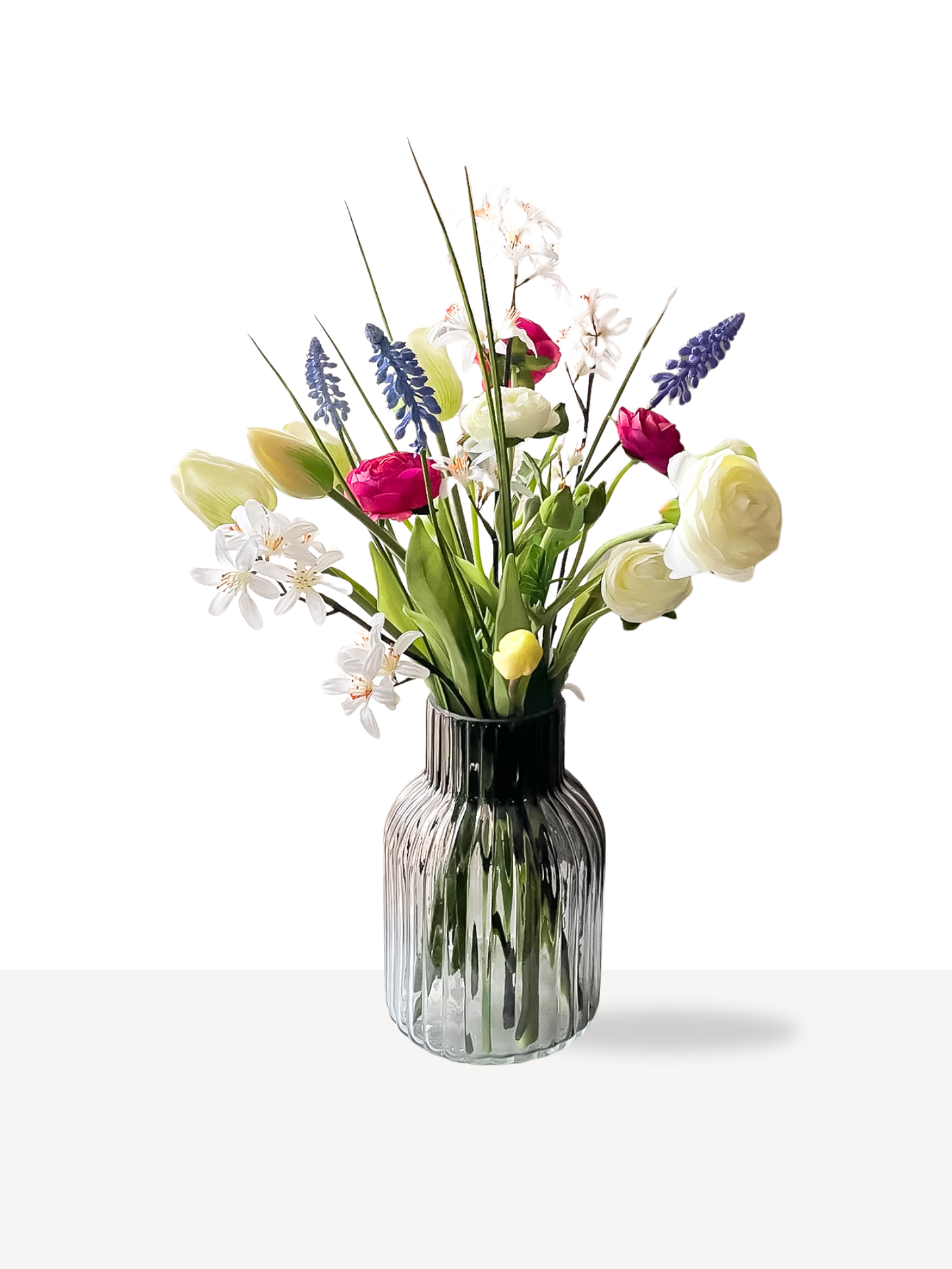 witten tulpen in voorjaarsboeket in zwarte transparante vaas