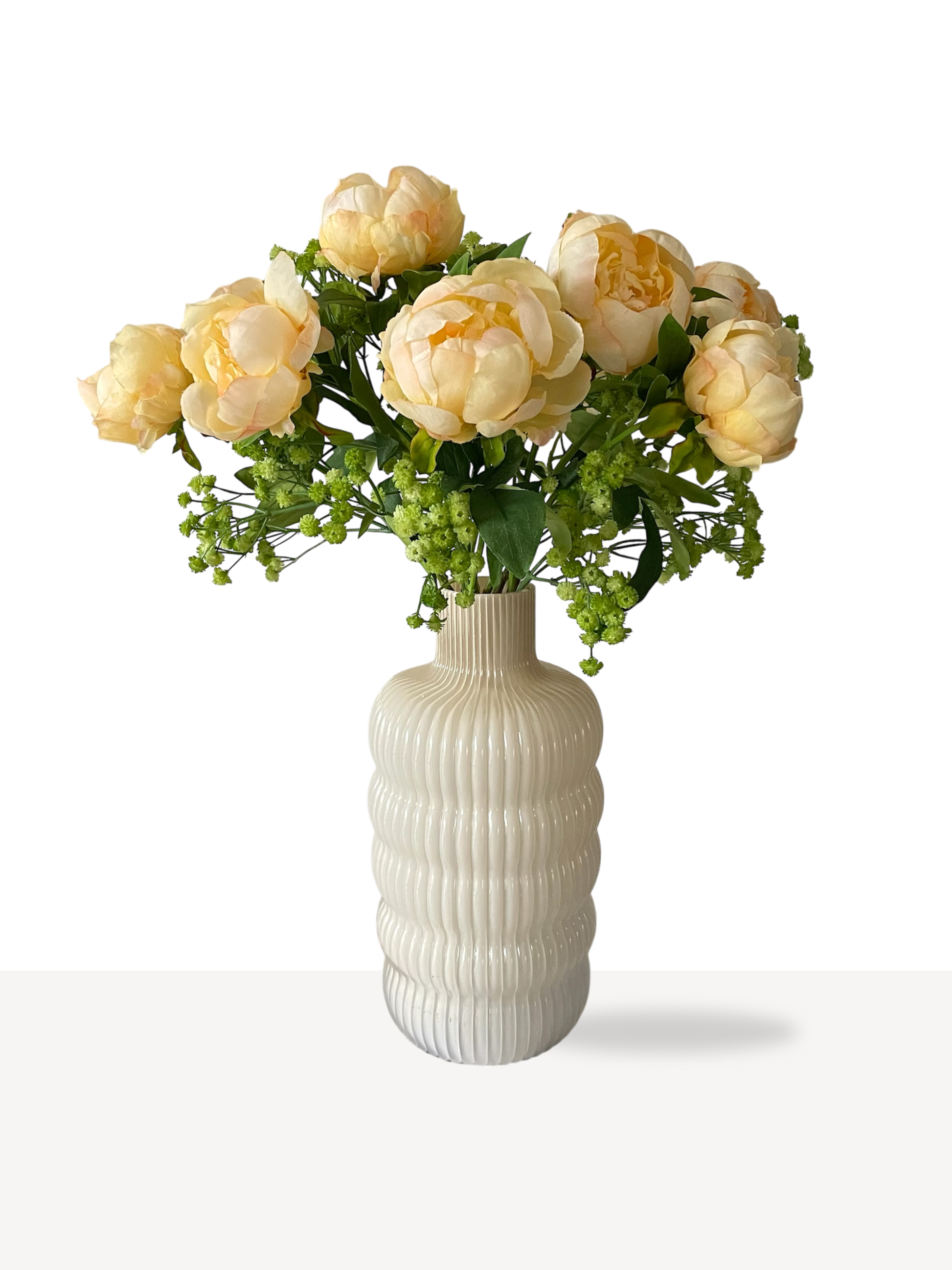 Gele pioenrozen met groen en peach vaas