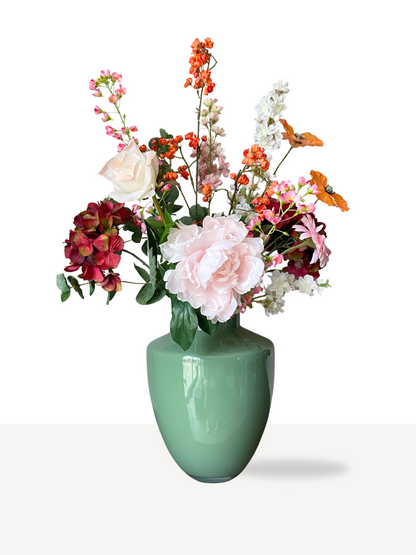 Zijden boeket met pioenroos, roos en hortensia in roze, oranje en wit in een groene vaas – luxe en onderhoudsvrij.