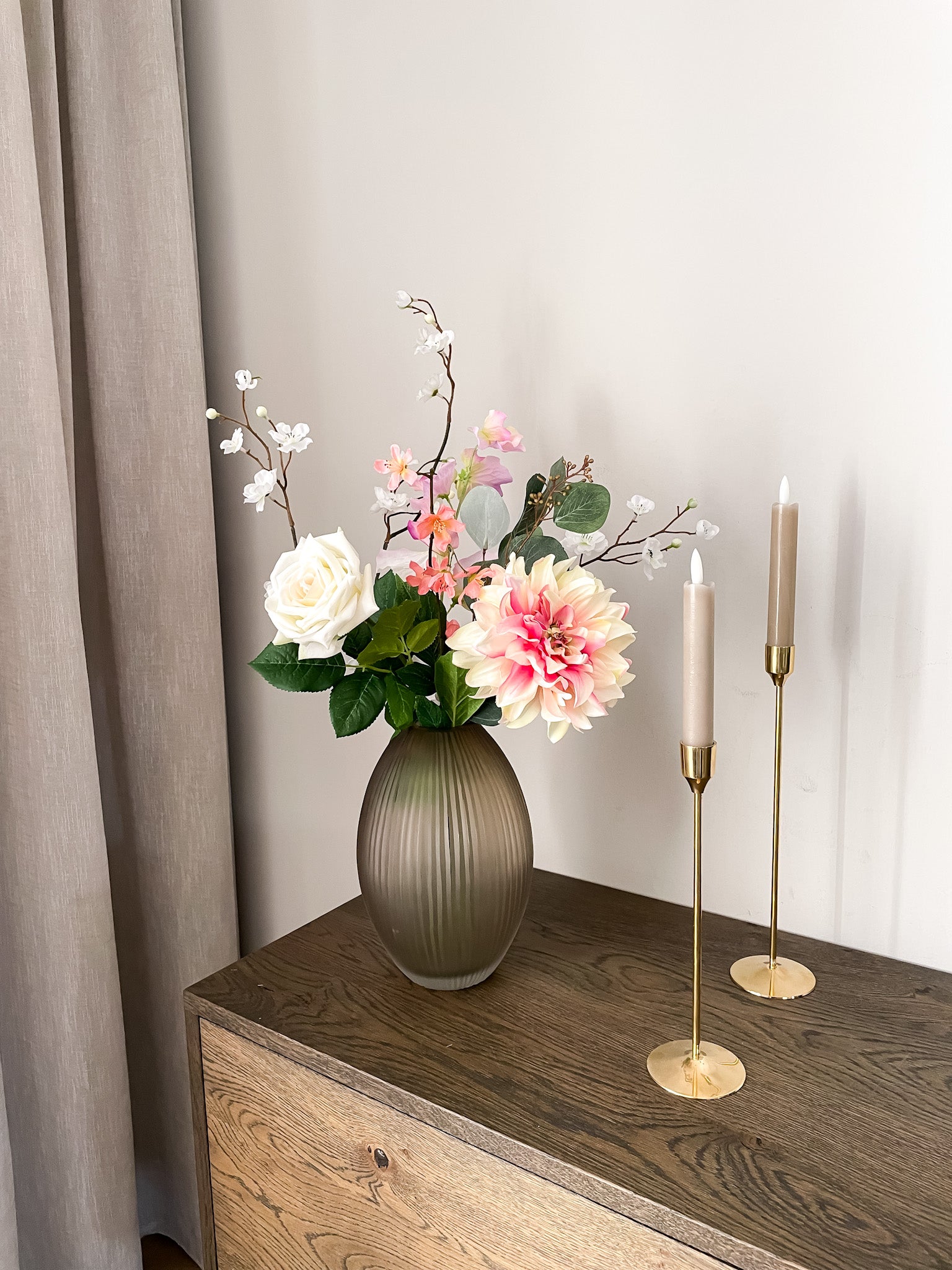 kleurrijk zijden boeket in ribbel vaas met kaarsen 